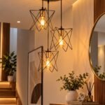 دلاية سقف مودرن سوداء 3 لمبات بتصميم قفص هندسي نجمي متداخل وحوامل ذهبية معلقة على ارتفاعات مختلفة داخل مدخل منزل عصري
