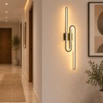 أبليك حائط ليد مودرن أسود بتصميم خطي هندسي وإضاءة دافئة داخل ممر مودرن